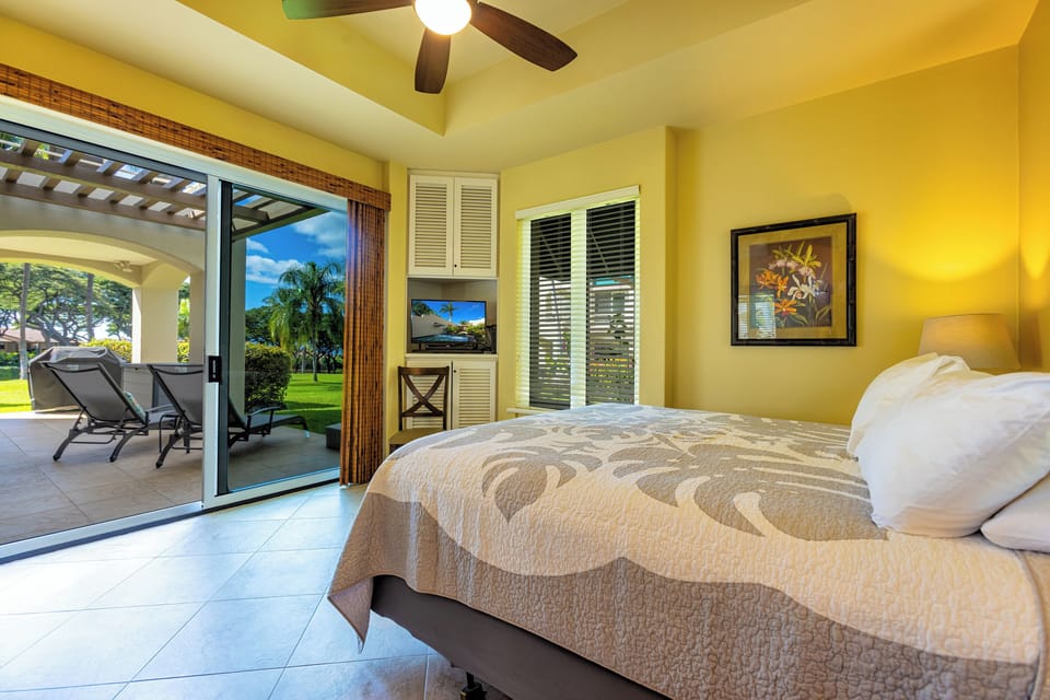 The main bedroom has a sliding door onto the large wrap-around lanai (two chaise-lounges just outside)