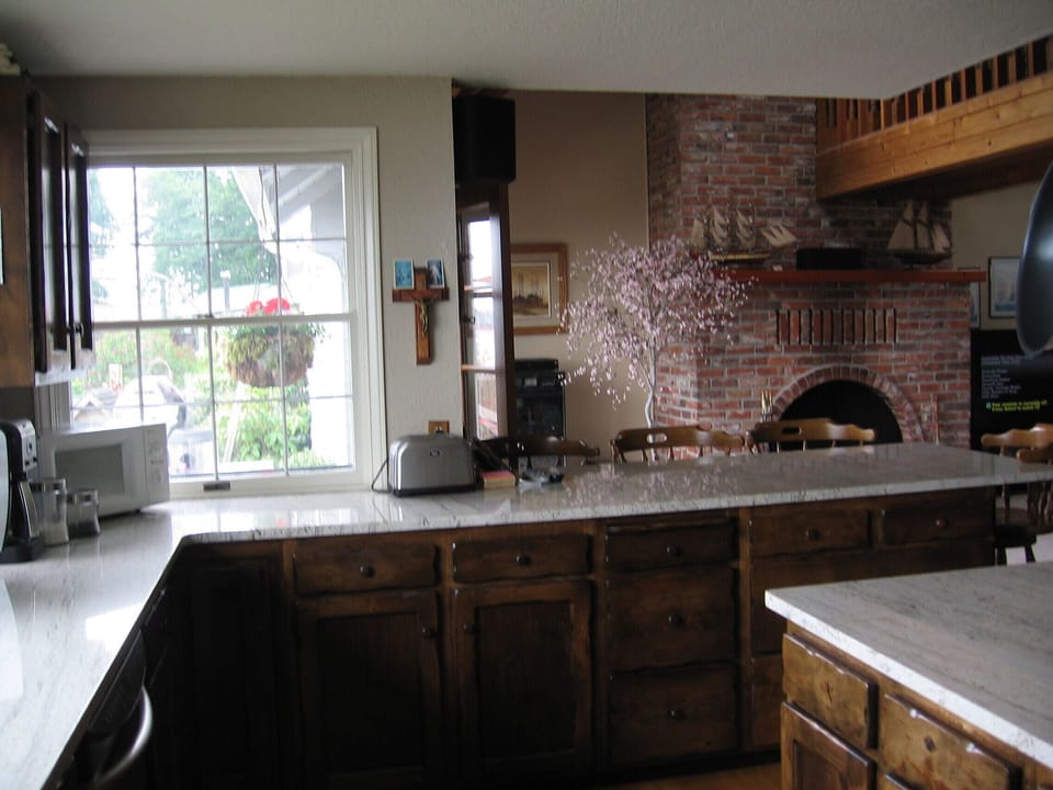 Looking from the Kitchen into a portion of the Den and Fireplace