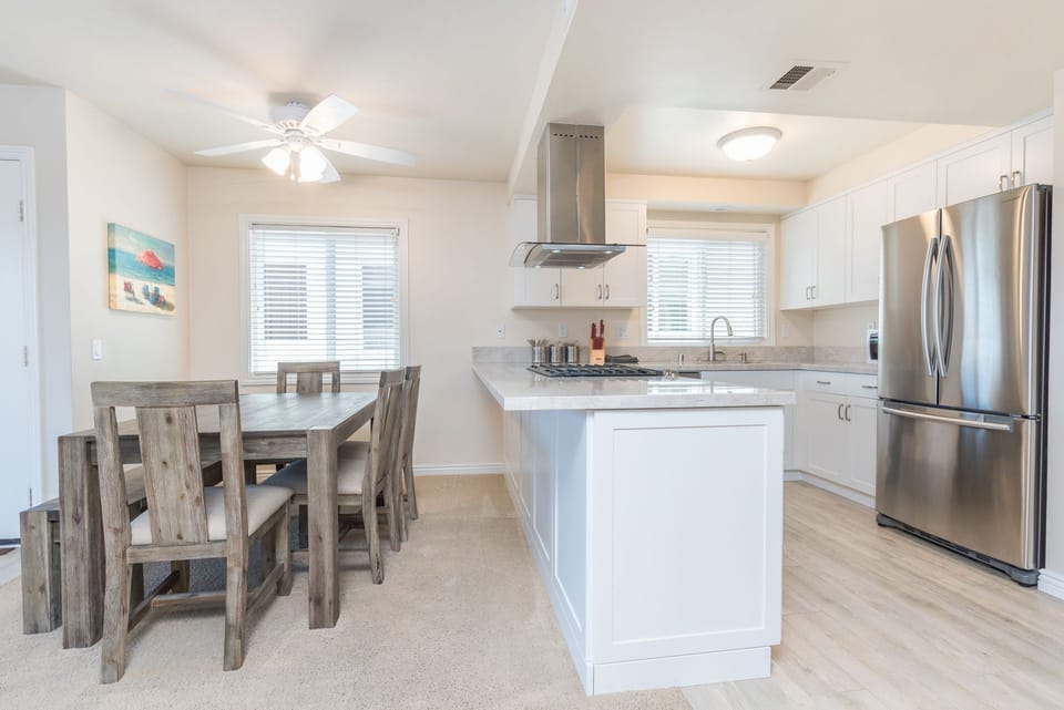 Family dining table sits adjacent to the kitchen on one side and living room on the other.
                