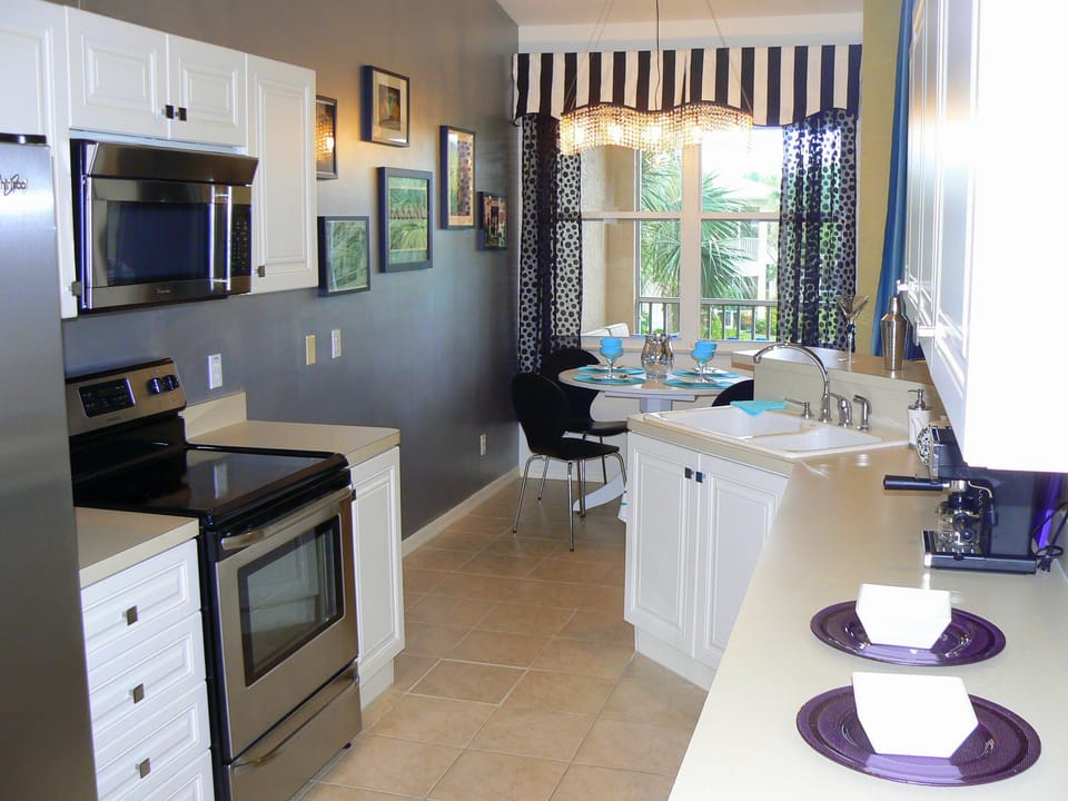 Designer kitchen with stainless appliances, silver accent wall.