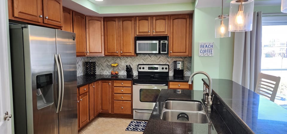 Large open kitchen to the dining room and high top bar with 3 stools. 