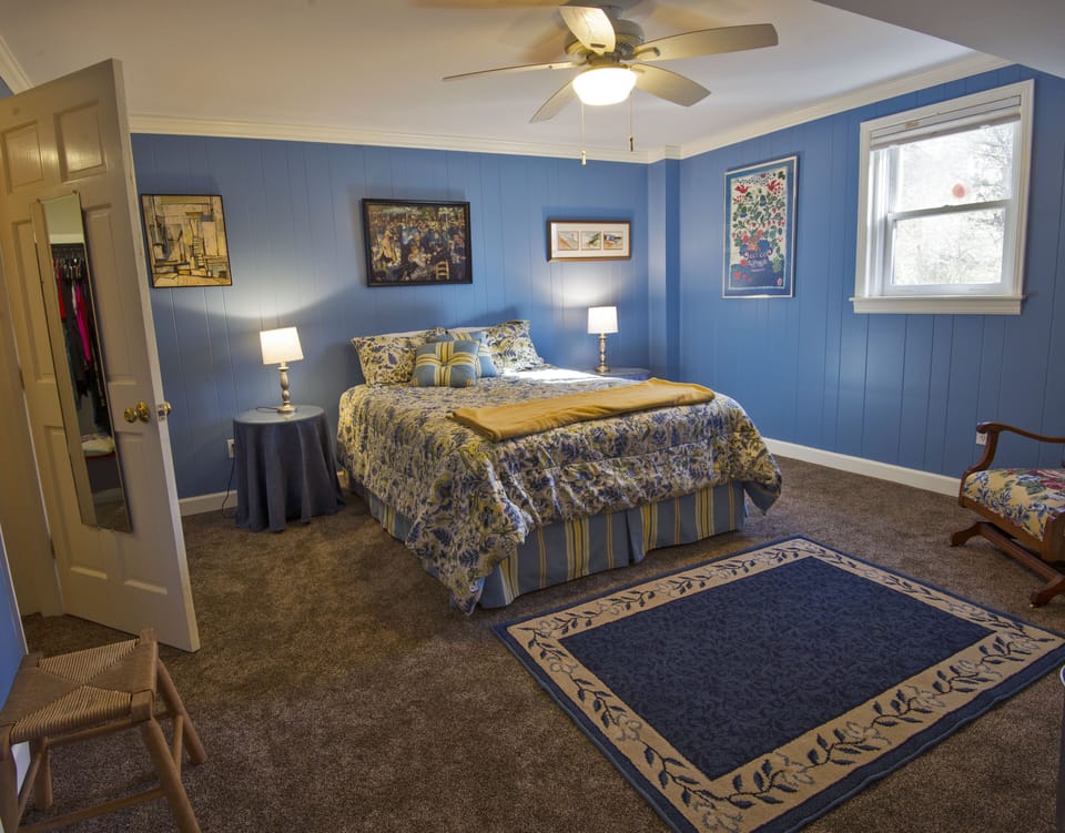Bedroom with queen bed and walk-in closet, ceiling fan