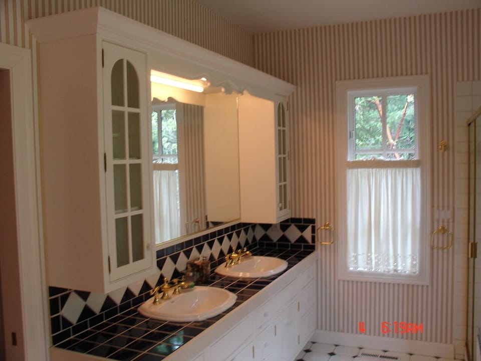 main bathroom has two sinks, a shower, a large bath, and sauna