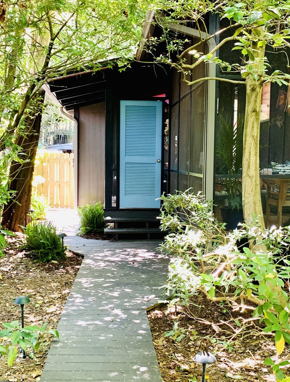 Private side entrance to the screened porch with living and dining areas.