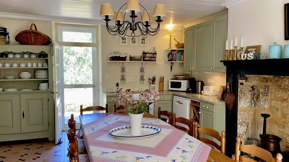 Kitchen/dining area seating 14 at the table. Doors to front and back terraces. 