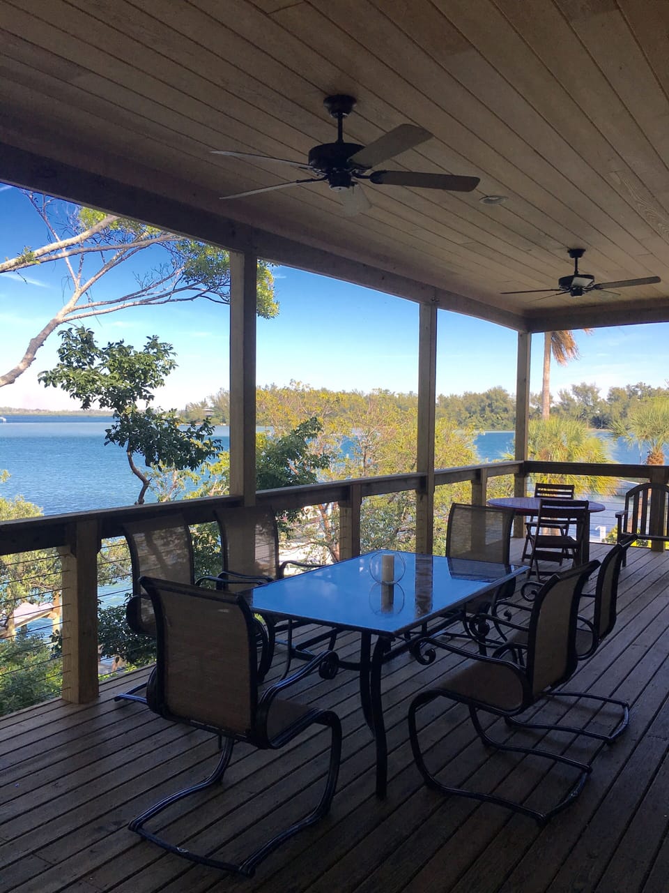 Covered terrace with table seating 6, two chairs and couch for enjoying the view