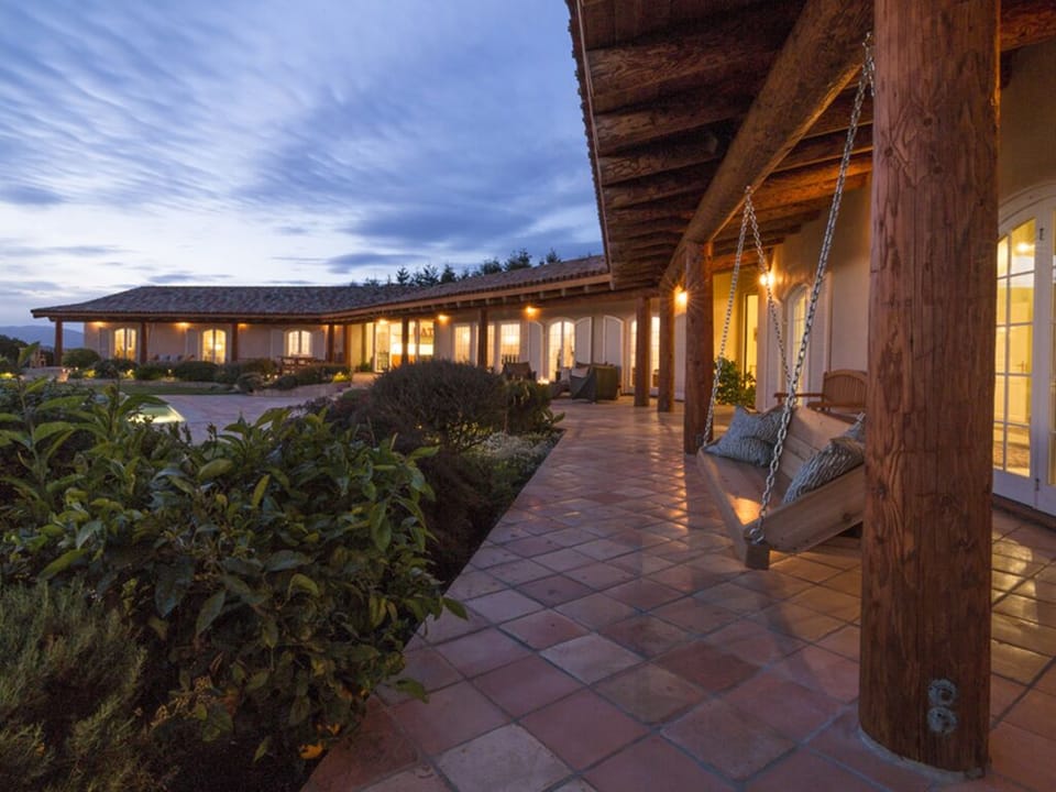 Two hanging bench swings under the eaves.