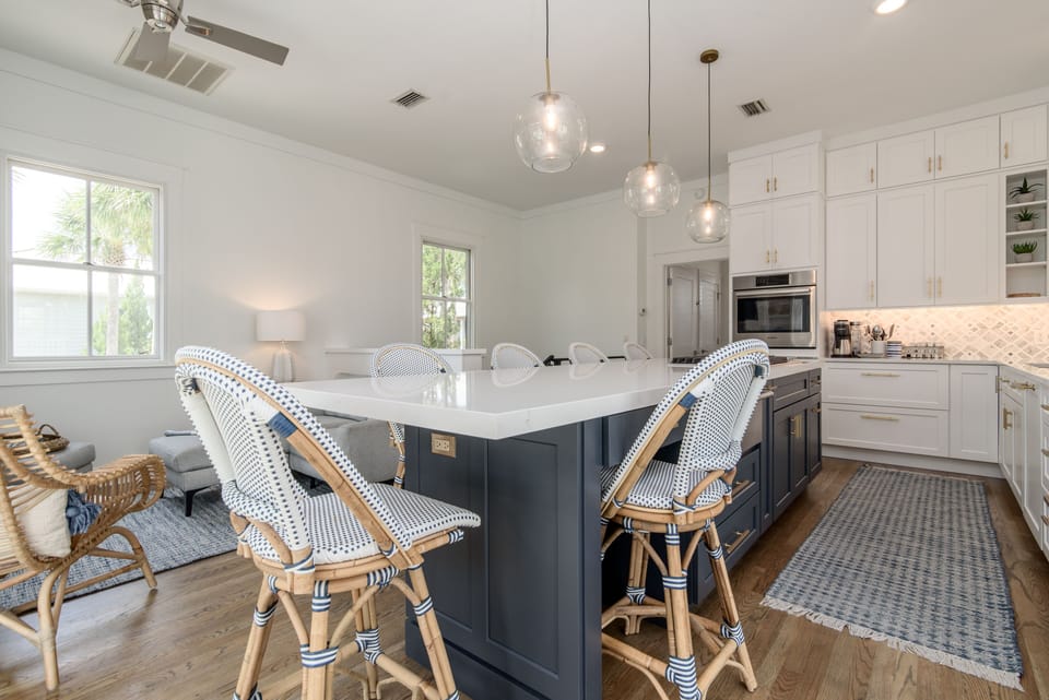 Fully stocked kitchen with bar seating for 7. Open concept with living room.