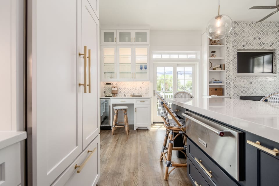 Paneled appliances and wine fridge in kitchen with tranquil office nook.