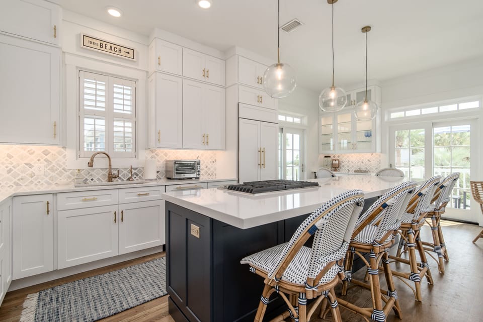 Chef's kitchen: gas grill, warming drawer, oven, microwave, and large island.