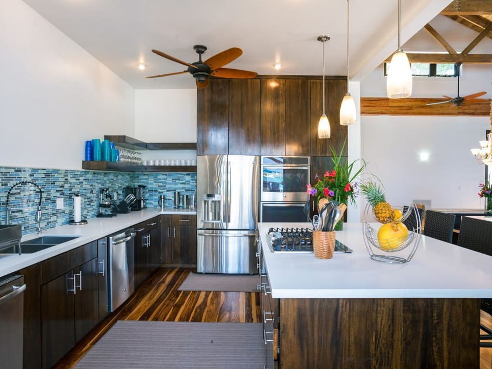 🌿 A gourmet space featuring a large social island, premium stainless steel appliances, and quality cookware. The open design keeps you connected to the Great Room and ocean views while you prep island-fresh meals. 🥂