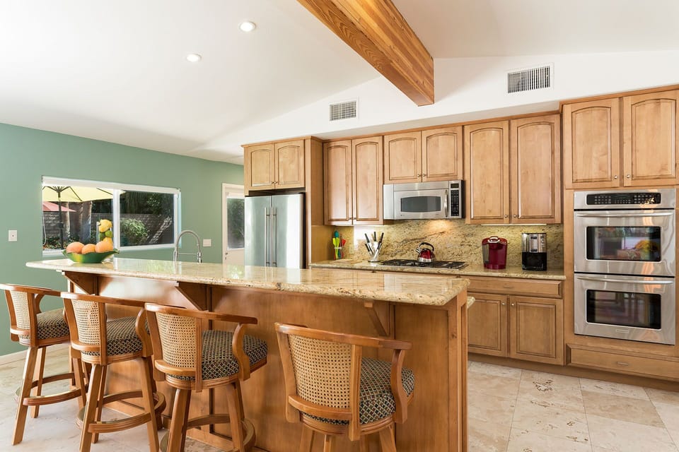 Bar and bar seating in kitchen.  Refrigerator, microwave, stove top and oven for your convenience. Pool views