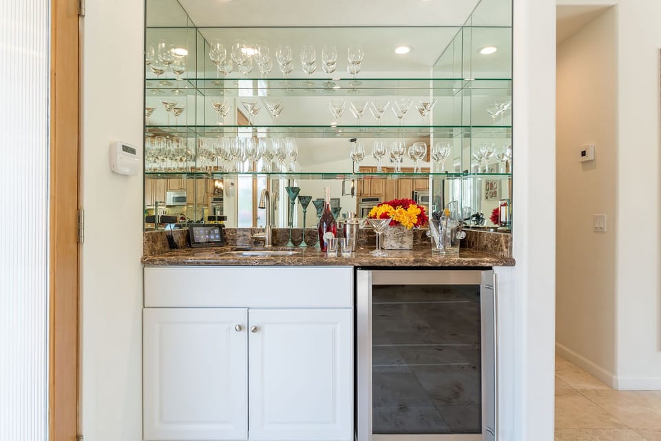 Interior bar area with glasses and wine refrigerator.  Ninja blender - Everything guests need to mix up favorite drinks to sit poolside!