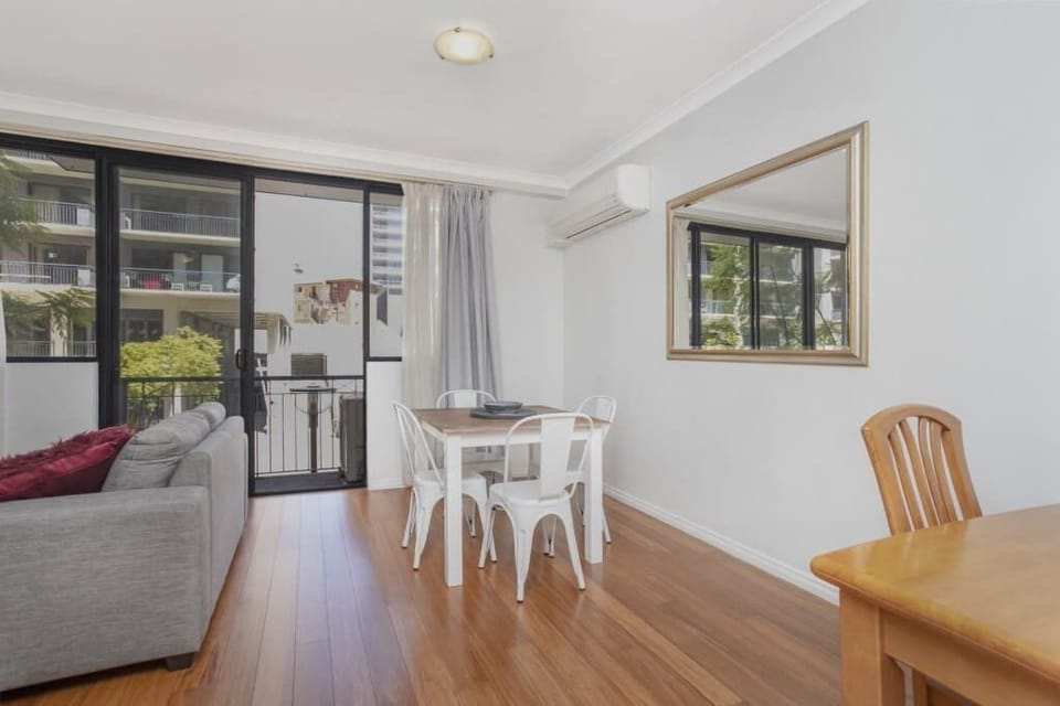 Bright and airy space with balcony access, comfortable seating, air conditioning, and a cozy dining area perfect for relaxing or enjoying a meal.