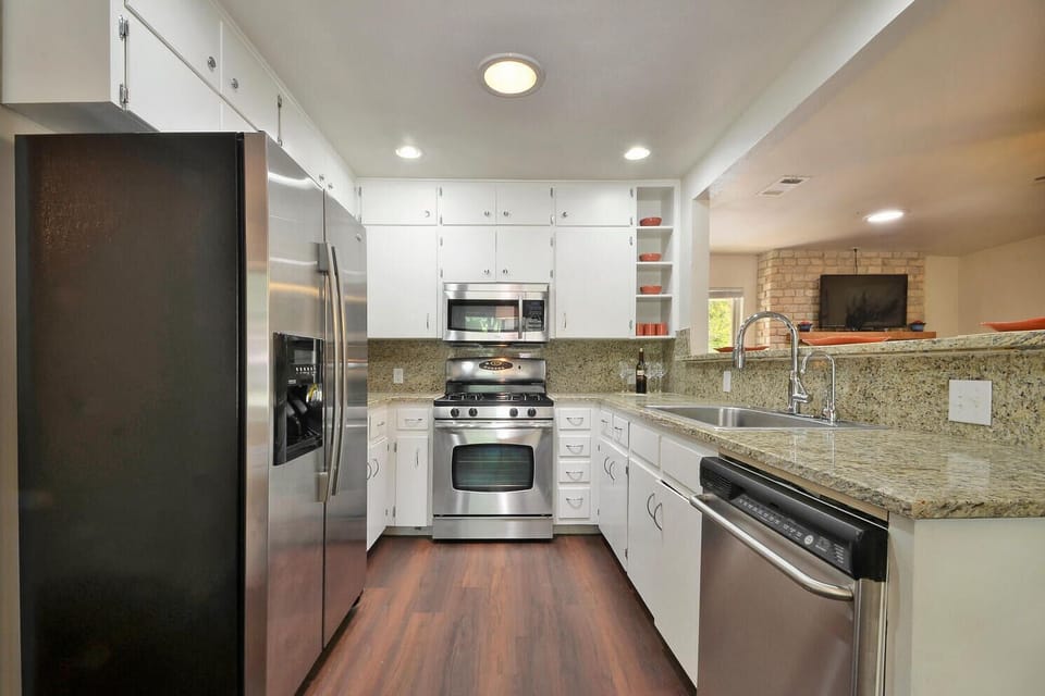 Fully equipped stylish kitchen with stainless appliances and granite countertops