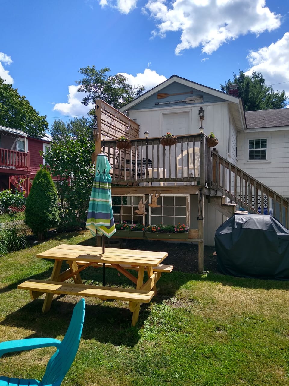 fenced in back yard with gas grill, picnic table and fire pit 