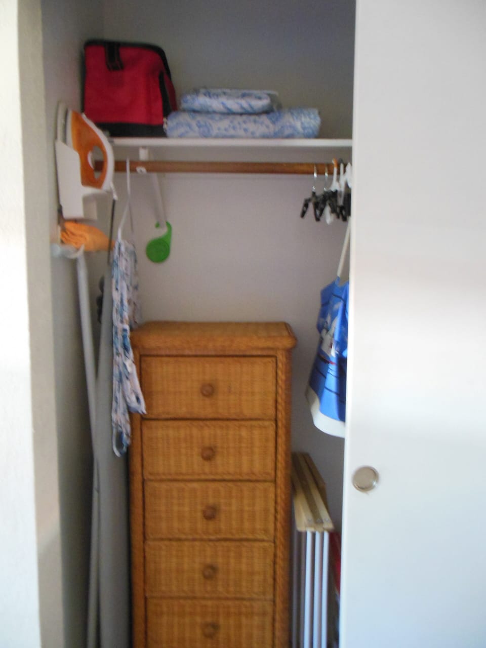 partial closet view with dresser, ironing board and iron
