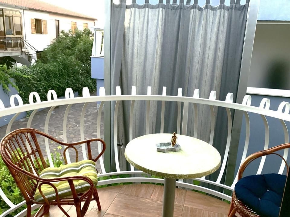 The bubble balcony with small table and two armchairs, view of the house next door