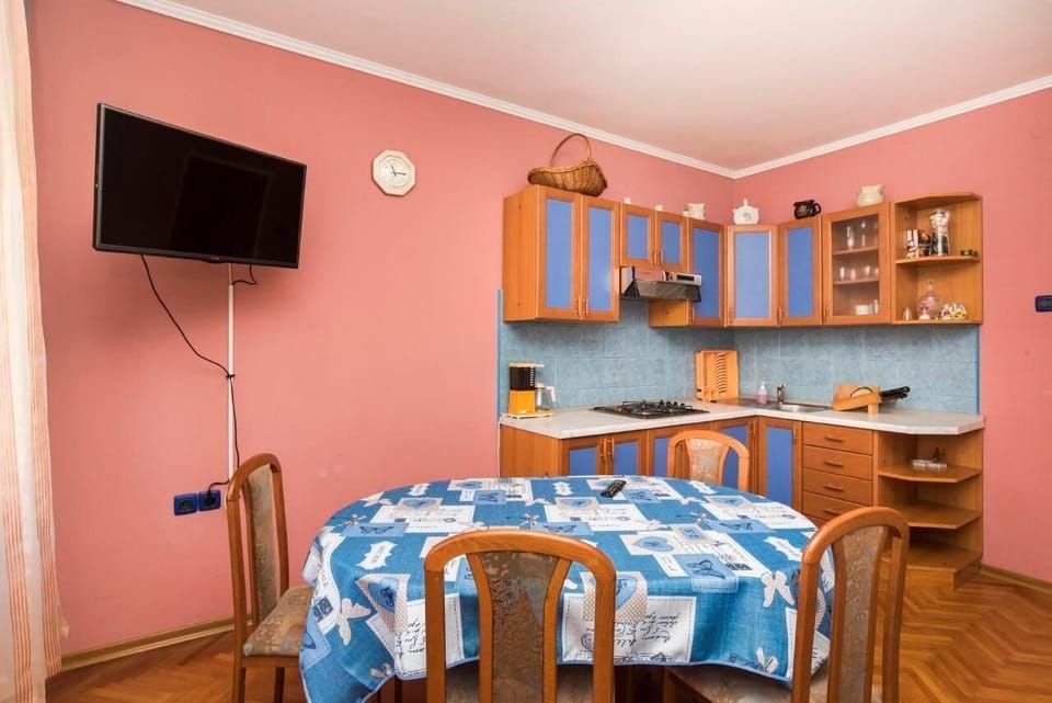 The equipped kitchen in the living area, flat-screen satellite TV, dining table with 4 chairs