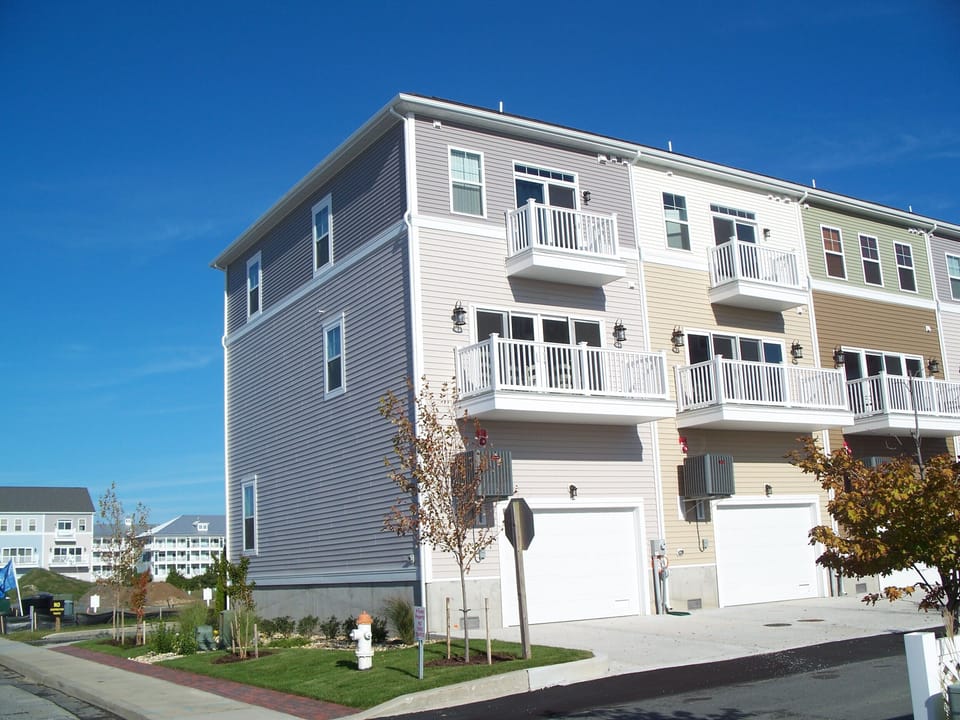 View of End Unit Townhouse with a 1 car garage & two parking spaces in the rear.