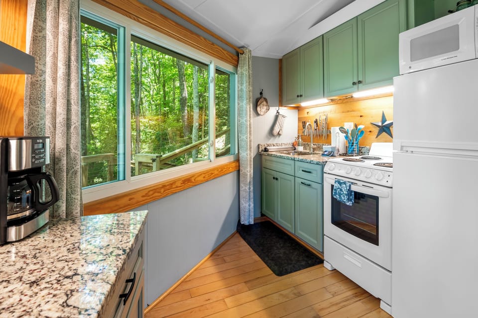 Stay in and prepare meals in this beautiful kitchen and enjoy the view. Updated kitchen with granite countertops, oven range, refrigerator, microwave. 