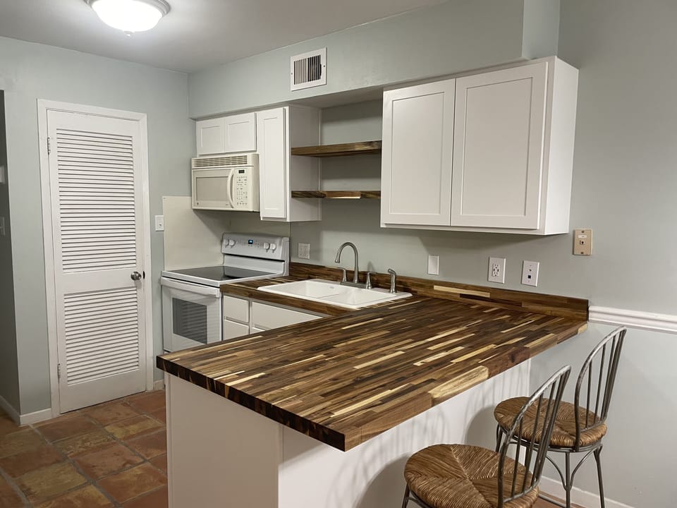 Open kitchen w/butcher block countertop, cast iron sink and slow close cabinets.