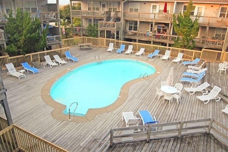 Pool and Central Deck Area With Lounge Chairs and Umbrella Topped Tables