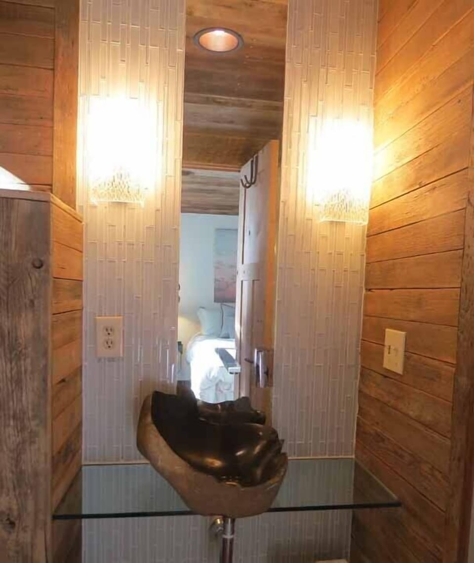 New bathroom vanity with carved boulder sink suspended on glass counter top 
