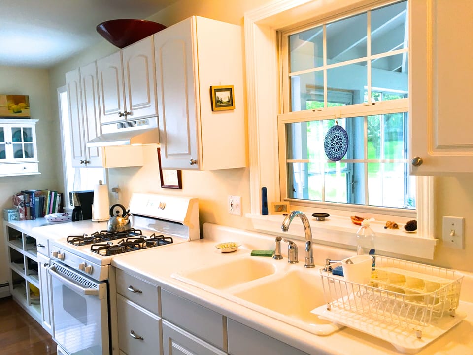 Kitchen with lots of windows looking onto screen porch and front deck.
