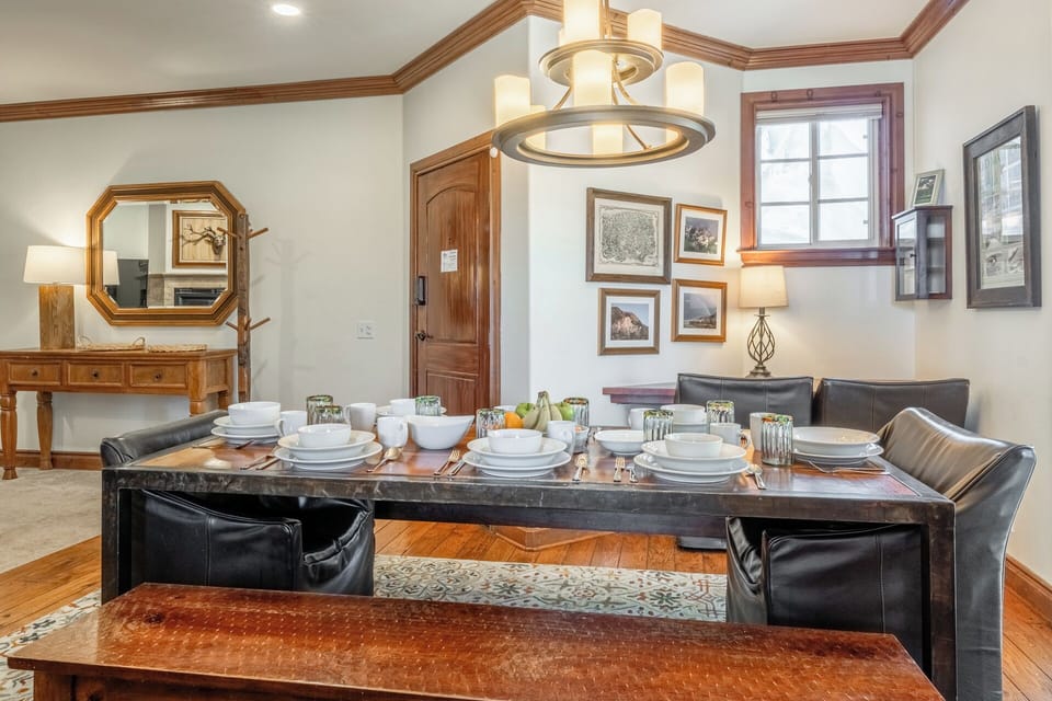 The Refined Retreat's light-filled dining area with floor-to-ceiling windows offers a dedicated workspace, tucked in the corner.