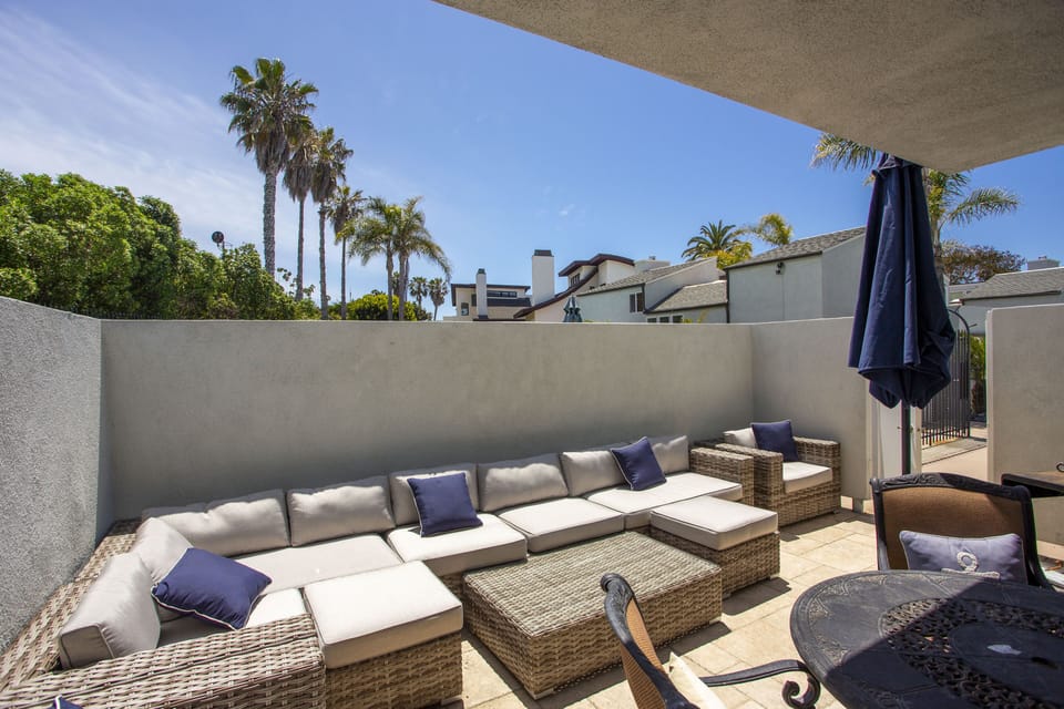 Large private outdoor patio area features a bbq, sofa, dining table.  