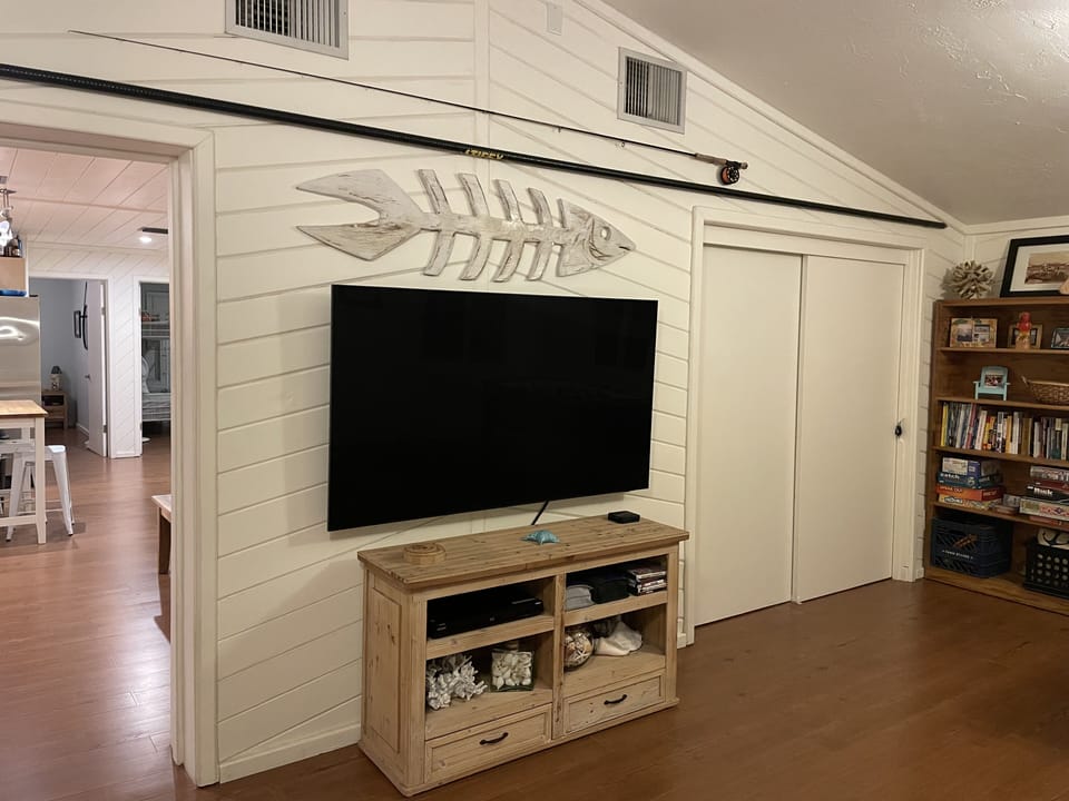 TV in living room area and doors to 3rd bedroom