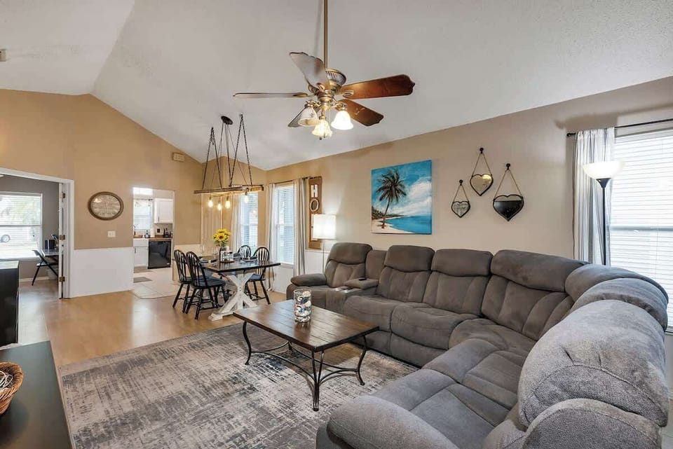 Beautifully decorated family room with large reclining couch w/massage & heater, 55" TV, sound bar, ceiling fan, farmhouse table and ladder chandelier (extra card tables & chairs in bedroom 4 closet).
