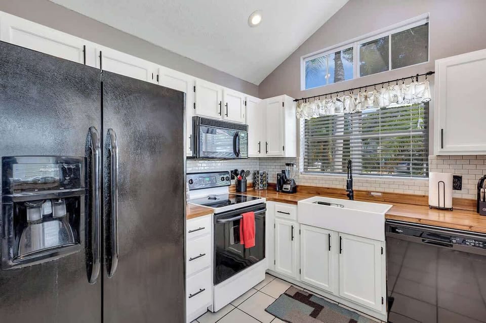 Newly renovated farmhouse kitchen complete with butcher block counter tops, white farmhouse sink, breakfast nook, Keurig Duo coffee & k-cup machine, tea kettle, coffee bar and fully stocked with plates, bowls, cups, utensils, appliances & pots/pans!