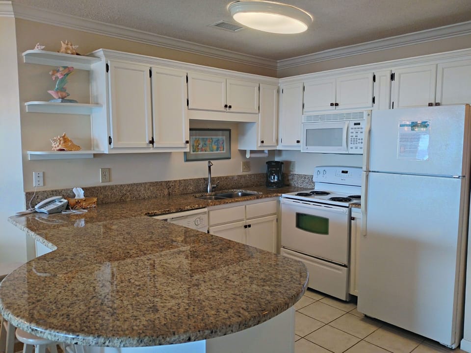 Well appointed kitchen with granite counters and tile floor