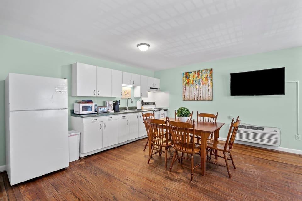 Your bright kitchen offers everything you need with full appliances, dining space for six, and cheerful mint walls creating a welcoming atmosphere.