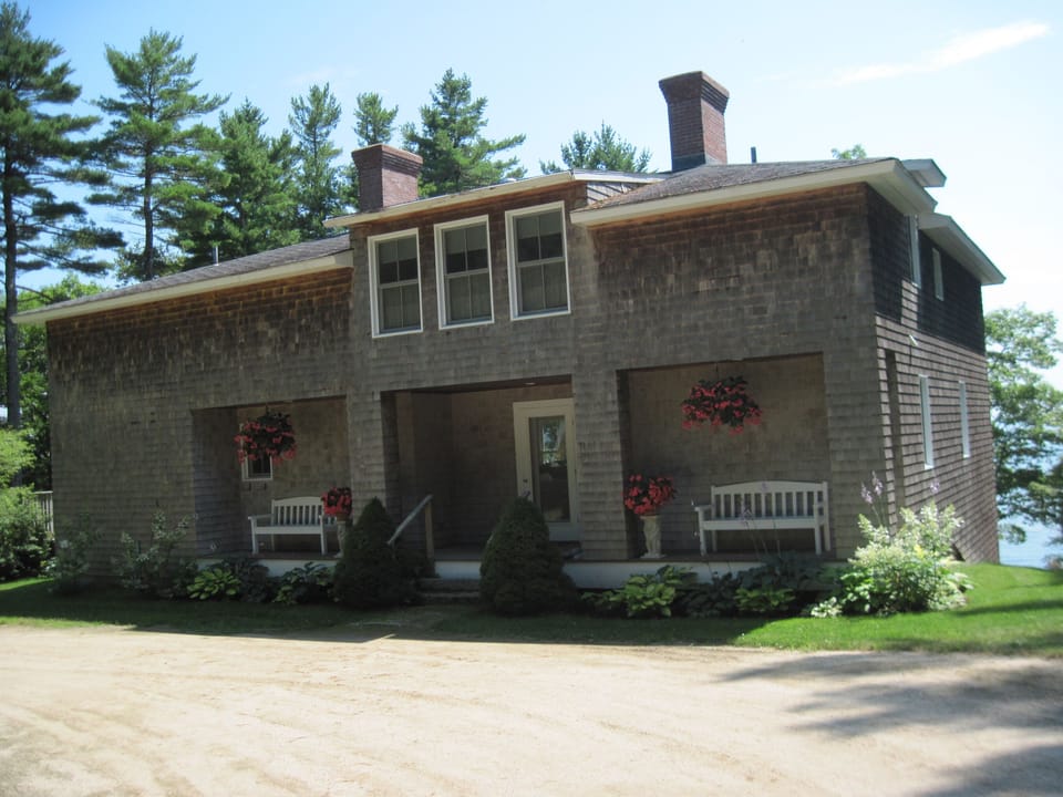 The house sits in a sunny location amid the pine trees.