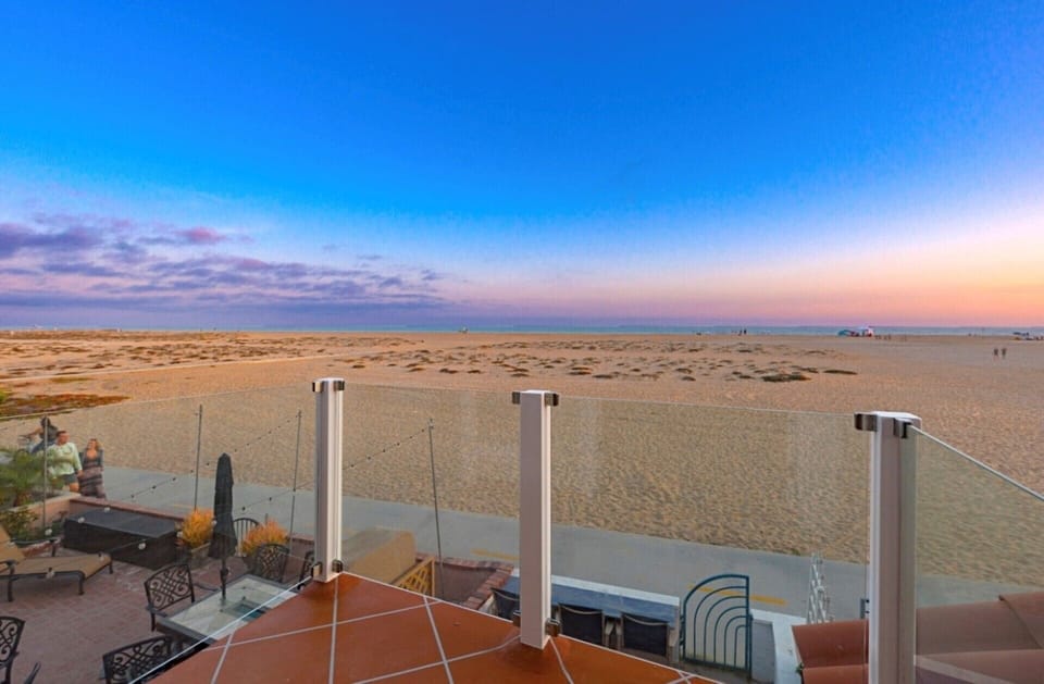 front balcony off of living room with views of the sunset.