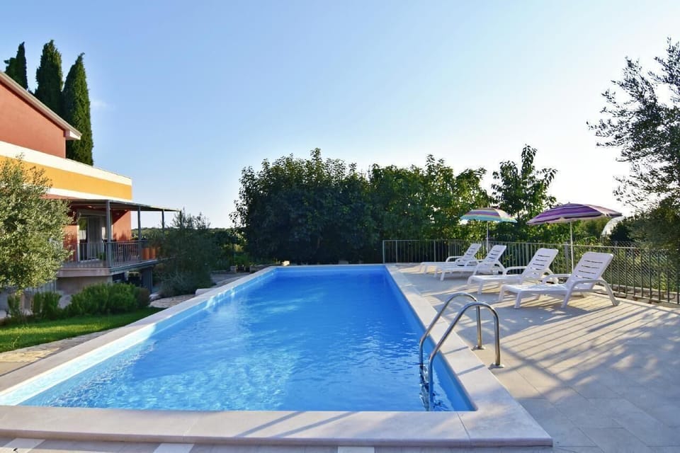The swimming pool of the house 4x10m with sun loungers and parasols and the house