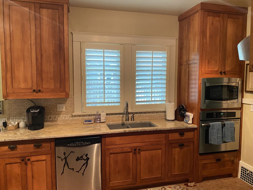 Kitchen equipped with GE Profile gas stove top, convection oven and microwave.
