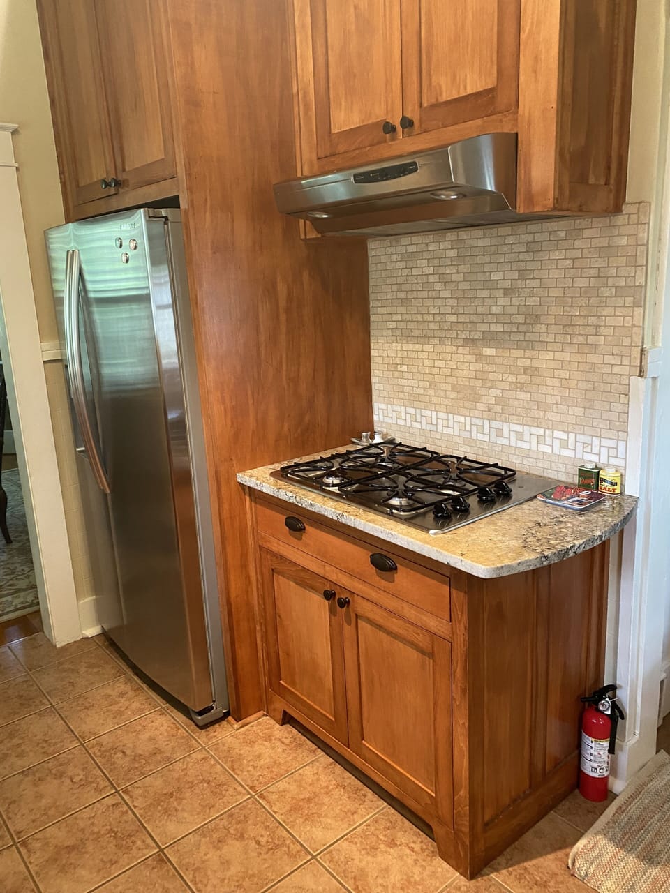 Kitchen equipped with GE Profile gas stove top, convection oven and microwave.