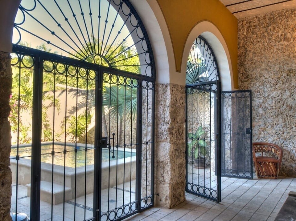 Covered and screened terrace opens into the gardens and pool