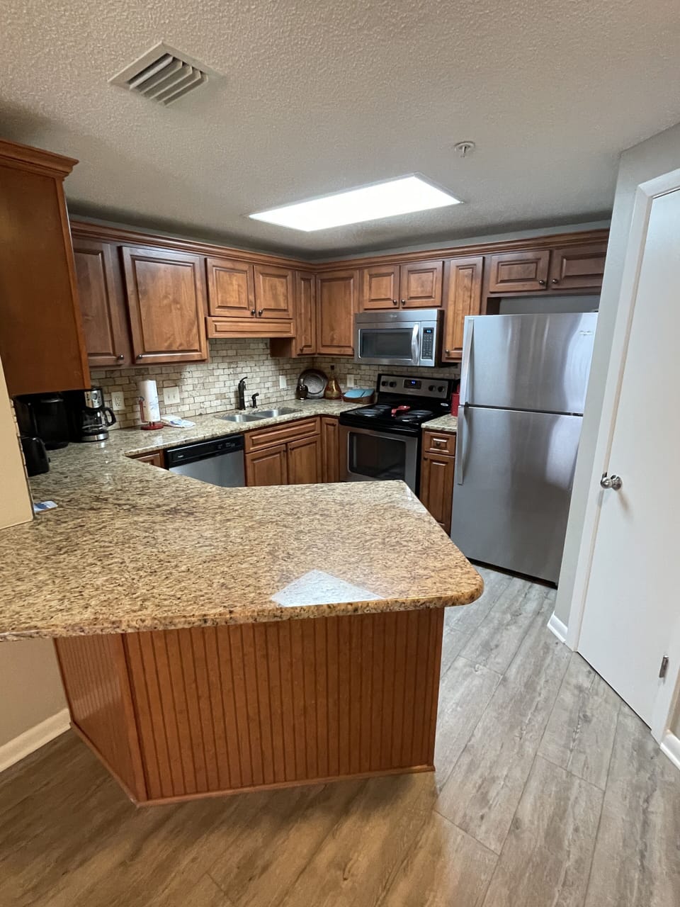 Kitchen with stainless refrigerator, stove, microwave & dishwasher.
