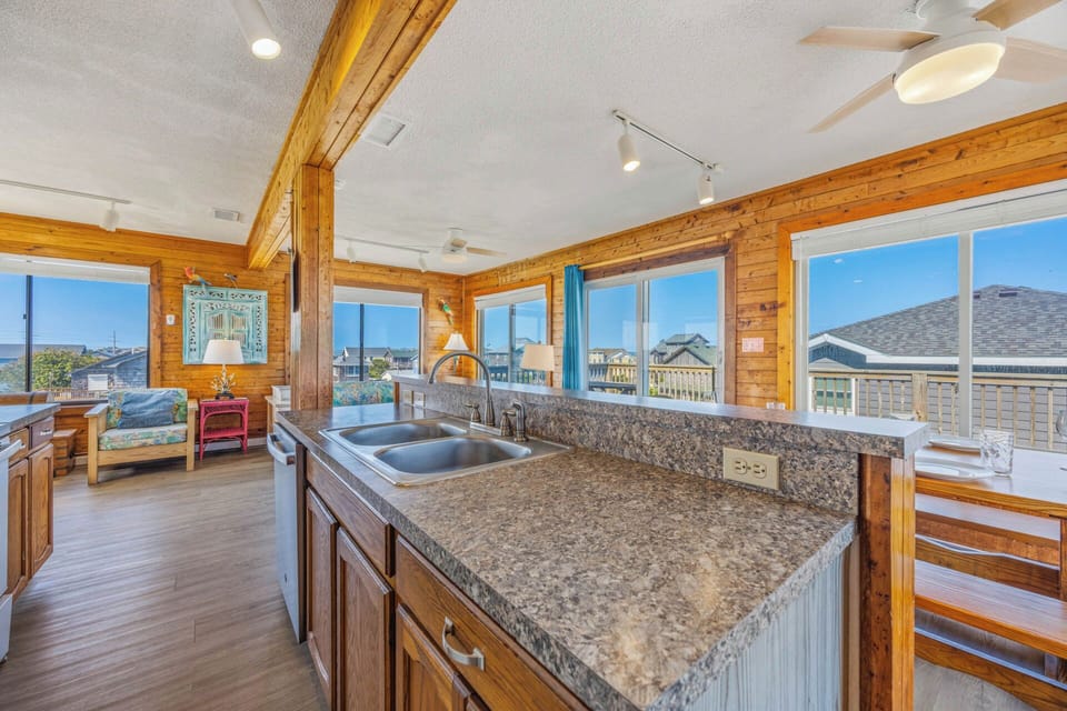 Picture yourself preparing meals at granite counters, warm wood beams overhead, as natural light pours through windows framing coastal views that'll make your morning coffee even better.