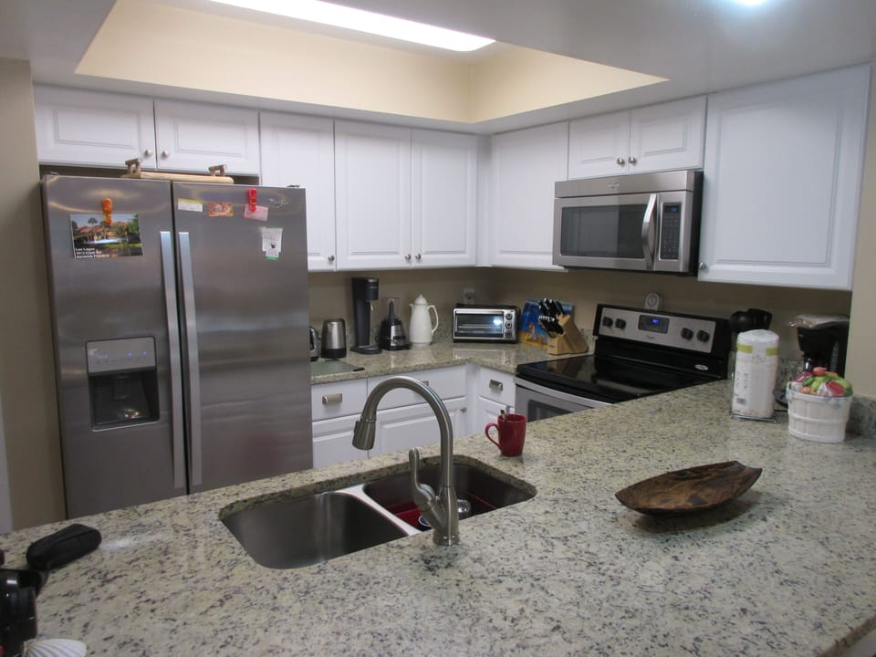 Kitchen with granite countertop, stainless steel utilities.