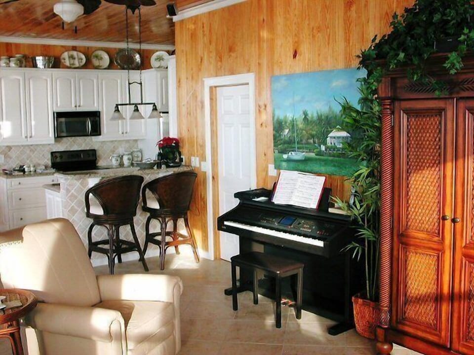 A Kauai electric piano is next to the armoire with a large flat screen TV.