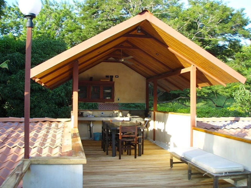 Covered outdoor kitchen with gas BBQ and dining area on 2nd floor.