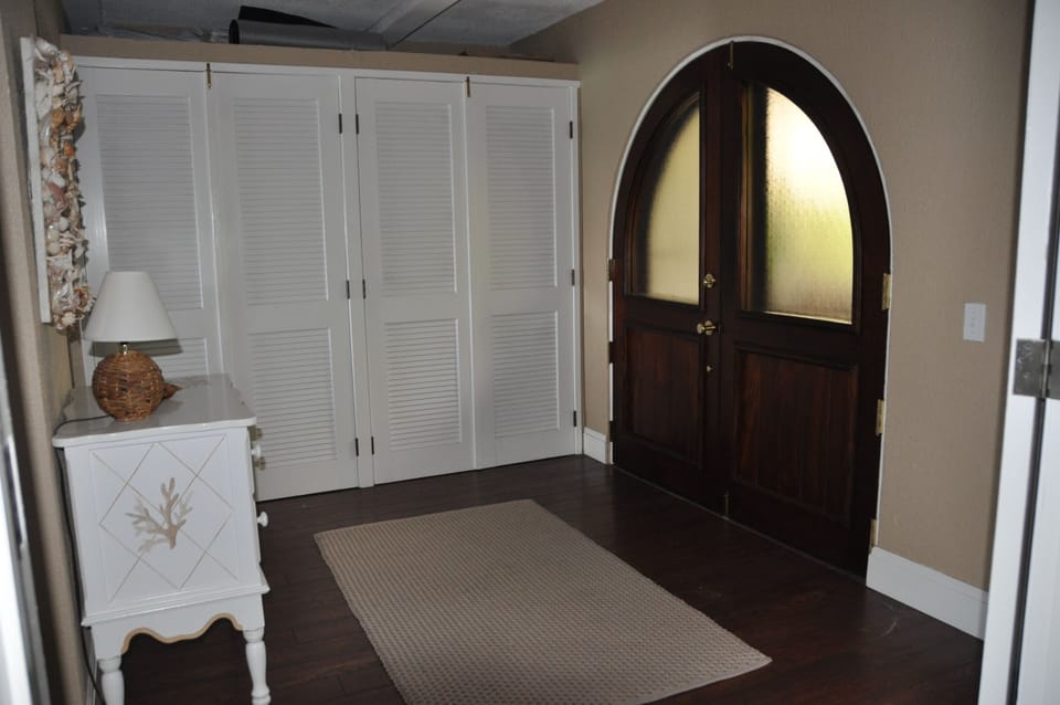 Full size washer and dryer behind closet doors in foyer