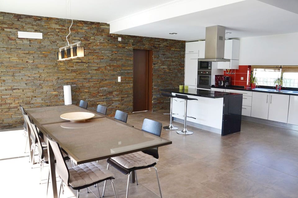 Open-plan kitchen and dining area with exposed brick feature wall — Villa Paraiso Comporta, holiday villa in Grândola