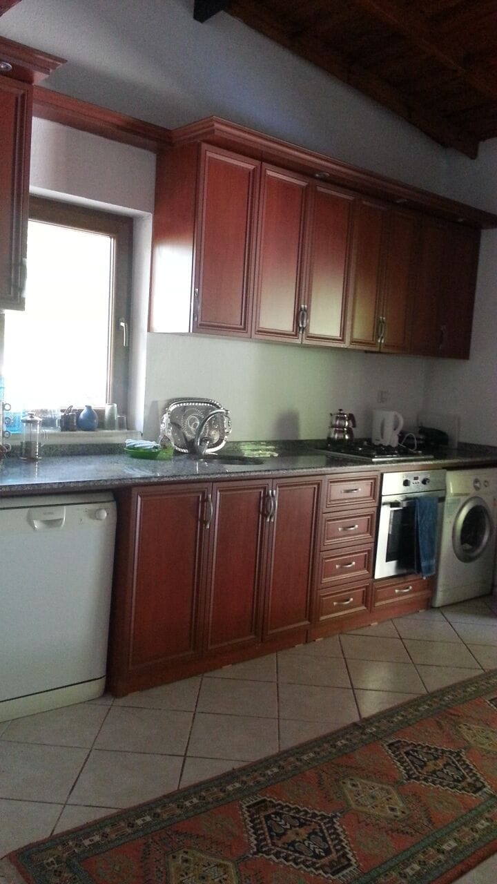 fully equipped kitchen with door to the terrace and pool area and garden